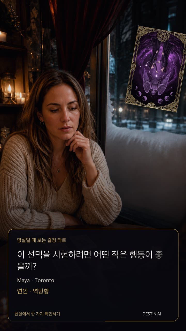 이 선택을 시험하려면 어떤 작은 행동이 좋을까? — 가로등 반사가 창에 비치는 토론토의 저녁 타로 카페. 타로 리더의 맞은편에 앉아 두 개의 작은 카드 더미 사이에 놓인 한 장 카드를 바라본다. 연인 · 역방향